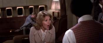 Movie still from “Airport '77” (1977), directed by Jerry Jameson – A woman in a beige jacket is talking to a man; Close Up shot, Over the shoulder angle