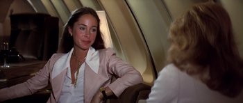 Movie still from “Airport '77” (1977), directed by Jerry Jameson – A woman sitting on top of an airplane next to another woman; Close Up shot, Over the shoulder angle