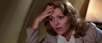Movie still from “Airport '77” (1977), directed by Jerry Jameson – A person holding her head; Close Up shot, High angle