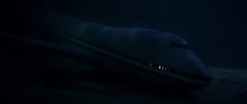 Movie still from “Airport '77” (1977), directed by Jerry Jameson – A large airplane is seen in the dark sky at night; Extreme Wide shot, Overhead angle