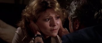 Movie still from “Airport '77” (1977), directed by Jerry Jameson – An older woman with her hands on her head; Close Up shot, Over the shoulder angle