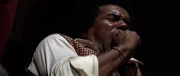 Movie still from “Airport '77” (1977), directed by Jerry Jameson – A person with a microphone on a stage; Extreme Close Up shot, Low angle