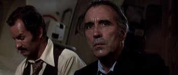 Movie still from “Airport '77” (1977), directed by Jerry Jameson – A person wearing a suit and tie; Close Up shot, Low angle