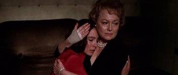 Movie still from “Airport '77” (1977), directed by Jerry Jameson – A woman is hugging a woman in a red dress; Close Up shot, Low angle