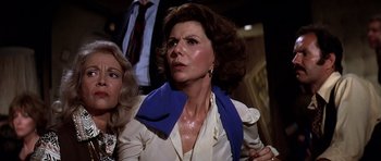 Movie still from “Airport '77” (1977), directed by Jerry Jameson – A person wearing a suit and tie; Close Up shot, Low angle