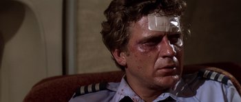 Movie still from “Airport '77” (1977), directed by Jerry Jameson – A person with a bandage on his face; Close Up shot, Low angle