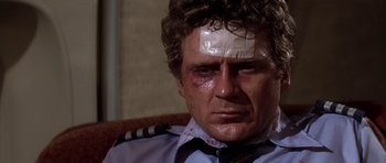Movie still from “Airport '77” (1977), directed by Jerry Jameson – A person with a bandage on his head; Close Up shot, Low angle