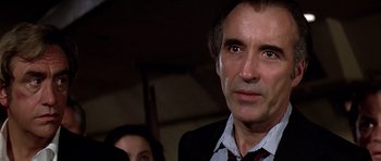 Movie still from “Airport '77” (1977), directed by Jerry Jameson – A person wearing a suit and tie; Close Up shot, Over the shoulder angle