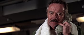 Movie still from “Airport '77” (1977), directed by Jerry Jameson – A person with a towel around his neck; Close Up shot, Low angle