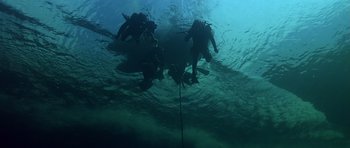 Movie still from “Airport '77” (1977), directed by Jerry Jameson – A group of scuba divers swimming under the surface of the water; Extreme Wide shot, High angle