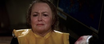 Movie still from “Airport '77” (1977), directed by Jerry Jameson – An older woman in a yellow shirt is crying; Close Up shot, High angle