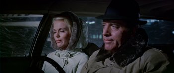 Movie still from “Airport” (1970), directed by George Seaton – A man and a woman sitting in the back of a car; Close Up shot, Low angle