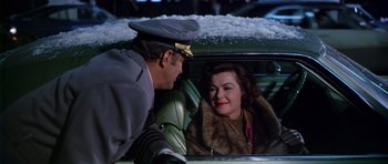 Movie still from “Airport” (1970), directed by George Seaton – A man and a woman in the back seat of a car; Medium shot, Over the shoulder angle