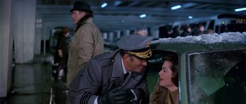 Movie still from “Airport” (1970), directed by George Seaton – A man in a military uniform is talking to a woman in an airport; Medium shot, Over the shoulder angle