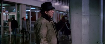 Movie still from “Airport” (1970), directed by George Seaton – A man wearing a hat and a jacket holding an electrical cord; Medium shot, Low angle