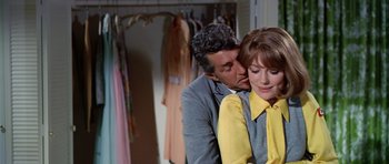 Movie still from “Airport” (1970), directed by George Seaton – A man and a woman are kissing in front of a closet; Medium shot, Over the shoulder angle