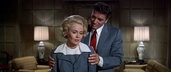 Movie still from “Airport” (1970), directed by George Seaton – A man and a woman in a suit and tie; Medium shot, Low angle