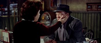 Movie still from “Airport” (1970), directed by George Seaton – An older man wearing a hat touching the face of a younger woman; Close Up shot, Over the shoulder angle