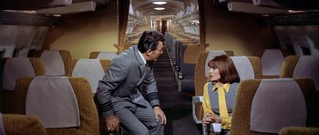 Movie still from “Airport” (1970), directed by George Seaton – A man and a woman sitting on a train; Wide shot, High angle