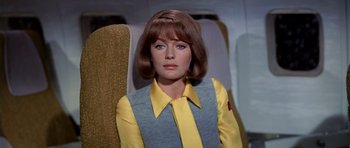 Movie still from “Airport” (1970), directed by George Seaton – A woman in a yellow shirt and a yellow tie; Close Up shot, Low angle