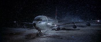 Movie still from “Airport” (1970), directed by George Seaton – An airplane that is sitting in the snow at night; Extreme Wide shot, High angle