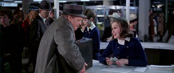 Movie still from “Airport” (1970), directed by George Seaton – A man and a woman are smiling at each other; Medium shot, Over the shoulder angle