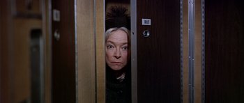 Movie still from “Airport” (1970), directed by George Seaton – An older woman peeking out from a door way; Close Up shot, Low angle