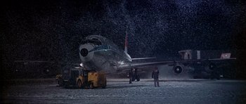 Movie still from “Airport” (1970), directed by George Seaton – An airplane on the ground in the snow at an airport; Extreme Wide shot, High angle