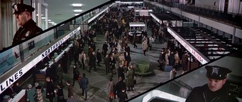 Movie still from “Airport” (1970), directed by George Seaton – A crowd of people walking around a train station; Extreme Wide shot, High angle