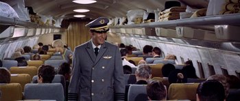 Movie still from “Airport” (1970), directed by George Seaton – A man in a uniform standing on a plane; Medium shot, High angle