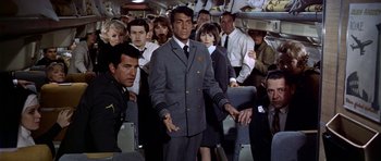 Movie still from “Airport” (1970), directed by George Seaton – A group of people sitting in a room; Medium shot, High angle