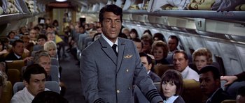 Movie still from “Airport” (1970), directed by George Seaton – A man in an air force uniform standing in front of a crowd; Medium shot, Over the shoulder angle