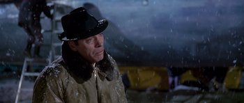 Movie still from “Airport” (1970), directed by George Seaton – A man wearing a hat and a coat in the snow; Close Up shot, Low angle