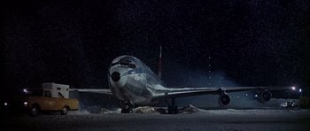 Movie still from “Airport” (1970), directed by George Seaton – An airplane sitting on top of an airport runway; Extreme Wide shot, Low angle