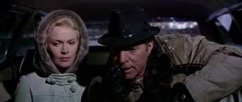 Movie still from “Airport” (1970), directed by George Seaton – A man and a woman in the back seat of a car; Close Up shot, Over the shoulder angle