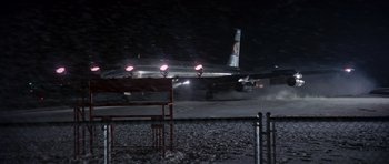 Movie still from “Airport” (1970), directed by George Seaton – An airplane on a runway at night with lights on; Extreme Wide shot, Low angle
