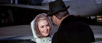 Movie still from “Airport” (1970), directed by George Seaton – A man and a woman are standing next to each other; Close Up shot, Over the shoulder angle