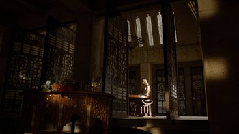 Movie still from “Game of Thrones” (2011), created by D.B. Weiss – A woman sitting at a table in a room; Extreme Wide shot, Low angle