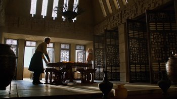 Movie still from “Game of Thrones” (2011), created by D.B. Weiss – A man and a woman standing in front of a table; Wide shot, Low angle