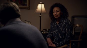 Movie still from “Better Call Saul” (2015), created by Vince Gilligan – A woman sitting in front of a man in front of a lamp; Medium shot, Over the shoulder angle