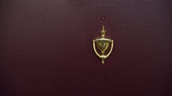 Movie still from “Better Call Saul” (2015), created by Vince Gilligan – A door knocker on a red door; Extreme Close Up shot, Overhead angle
