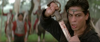 Movie still from “Asoka” (2001), directed by Santosh Sivan – A man holding a knife with blood all over it; Close Up shot, Low angle