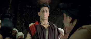 Movie still from “Asoka” (2001), directed by Santosh Sivan – A man in a roman costume with a head tattoo; Close Up shot, Over the shoulder angle