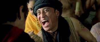 Movie still from “Asoka” (2001), directed by Santosh Sivan – A man with a beard and a hat is laughing; Close Up shot, Low angle