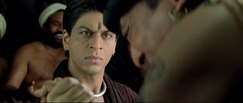 Movie still from “Asoka” (2001), directed by Santosh Sivan – A man with a tattoo on his face is looking into the mirror; Close Up shot, Over the shoulder angle