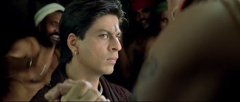 Movie still from “Asoka” (2001), directed by Santosh Sivan – A person with a tattoo on his face; Close Up shot, Over the shoulder angle
