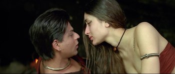 Movie still from “Asoka” (2001), directed by Santosh Sivan – A man and a woman face to face in front of a dark background; Close Up shot, Low angle