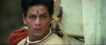 Movie still from “Asoka” (2001), directed by Santosh Sivan – A person wearing a necklace; Close Up shot, High angle