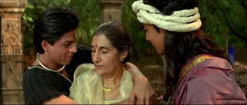 Movie still from “Asoka” (2001), directed by Santosh Sivan – A woman is sitting on the lap of two other women; Medium shot, High angle