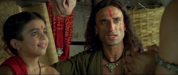 Movie still from “Asoka” (2001), directed by Santosh Sivan – A man with long black hair and a forehead tattoo; Close Up shot, Low angle
